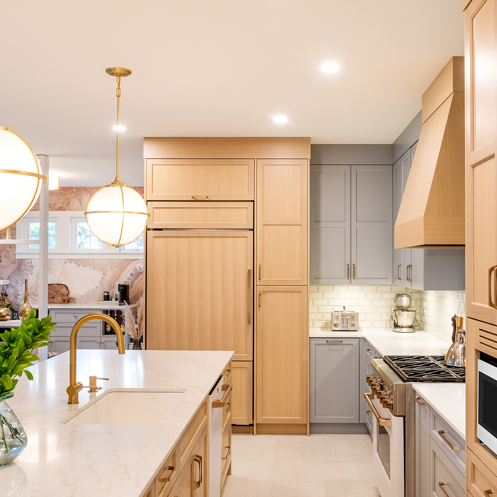 Crescent Living kitchen with grey and wood cabinetry, an island sink and globe pendant lights