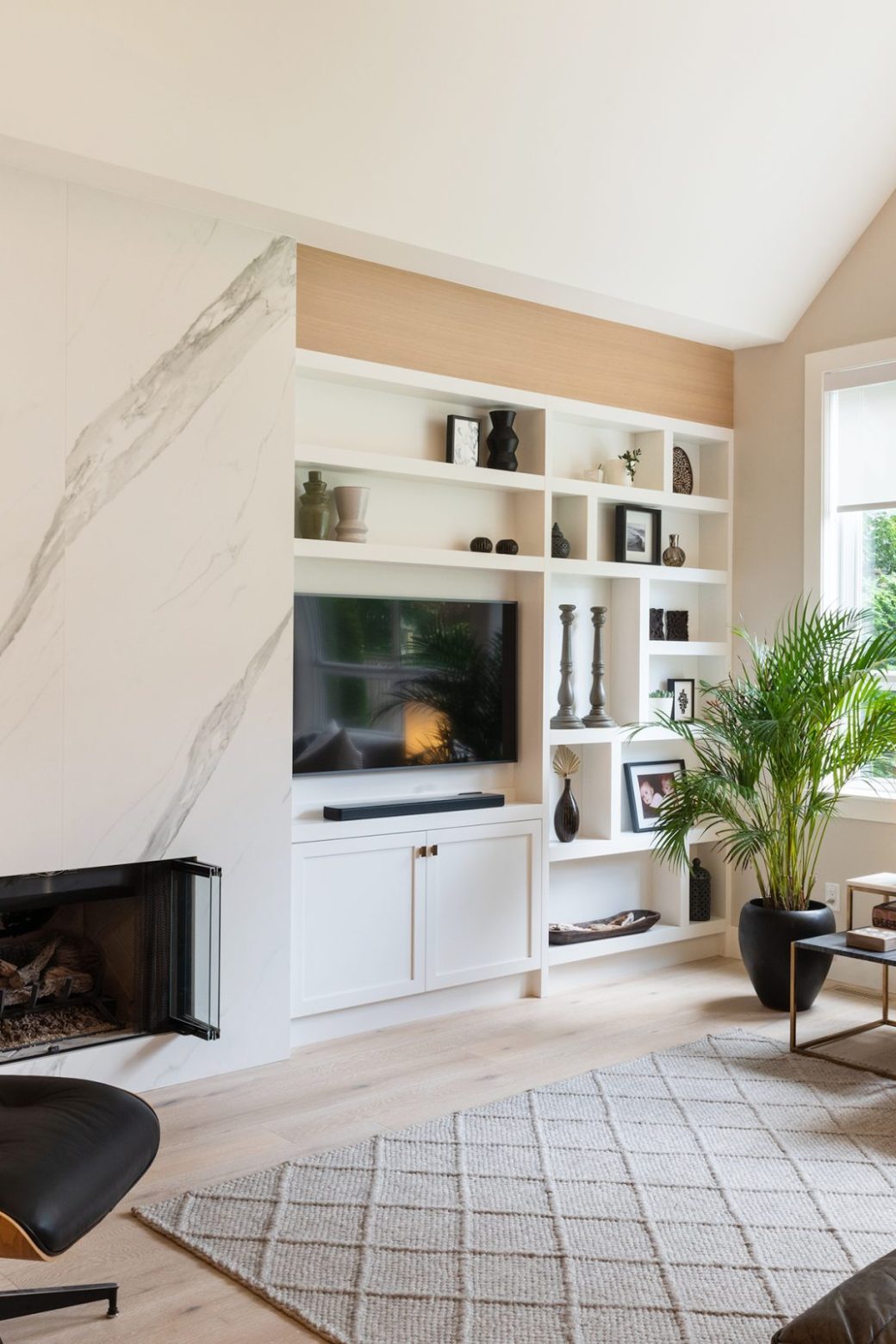 Crescent Living living room with a tall fireplace surround, white built-in shelving and large windows