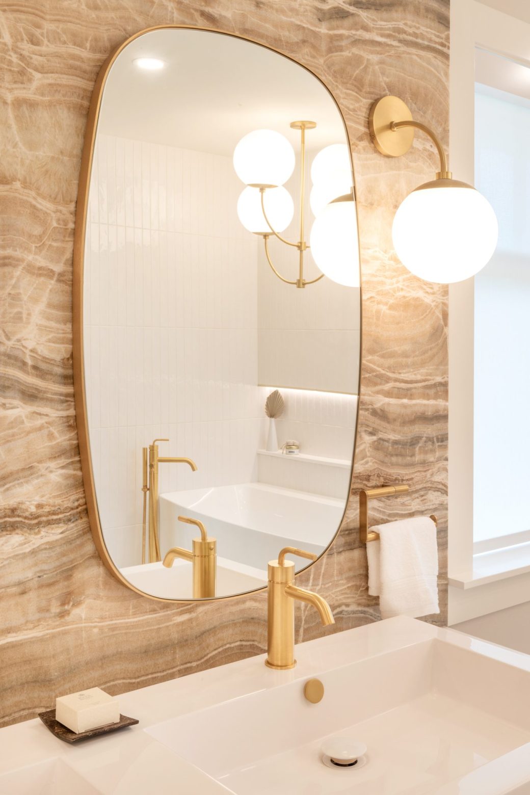 Crescent Living bathroom vanity with an oval mirror, globe wall light and gold-toned faucet