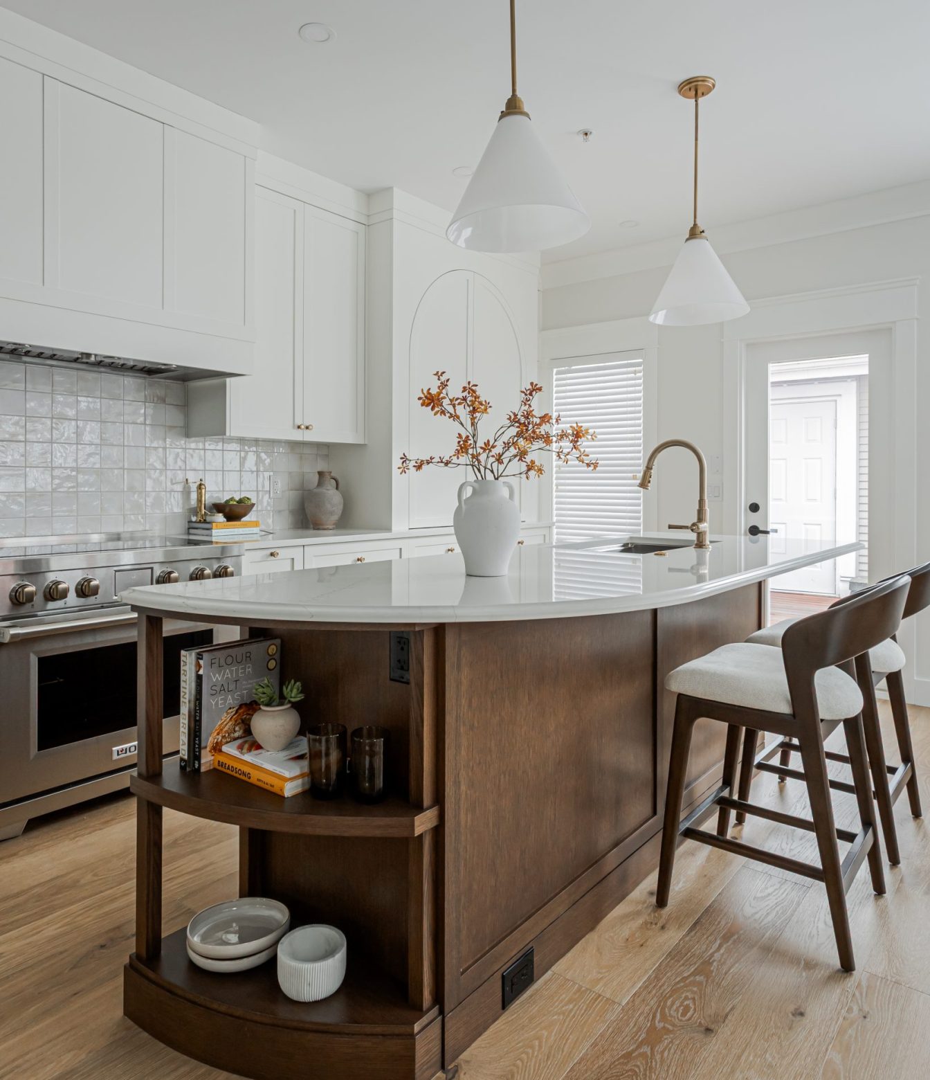 Hidden in Plain Sight kitchen island with a curved wood end, open shelves and white pendant lights