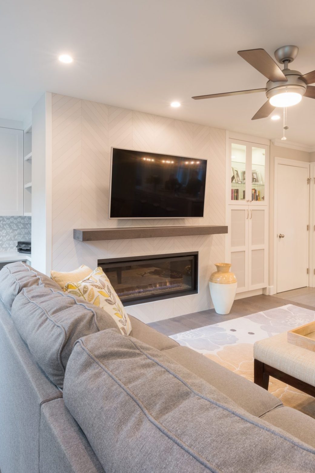 Living room fireplace with a wall-mounted television and a built-in desk with white cabinetry.